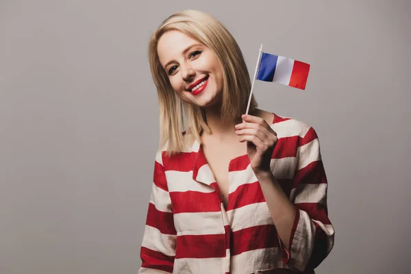 喜怒无常的女孩在灰色背景下举着法国国旗 — 图库照片