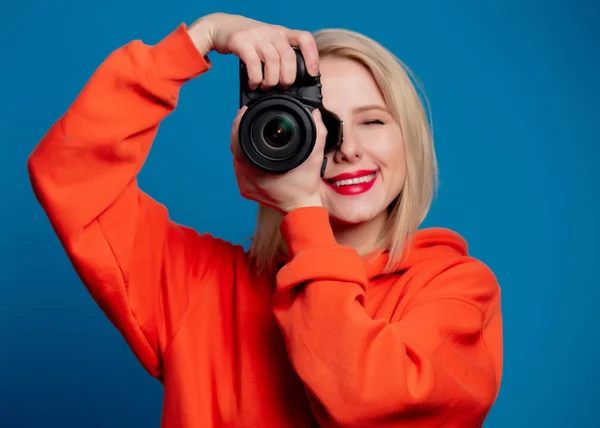 Mooi Meisje Houdt Camera Blauwe Achtergrond — Stockfoto