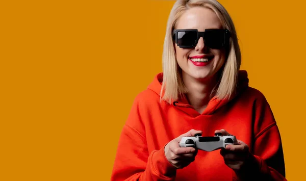 Girl in sunglasses keen plays with a joystick — Stock Photo, Image