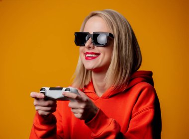 Güneş gözlüklü kız, joystick ile oynuyor.