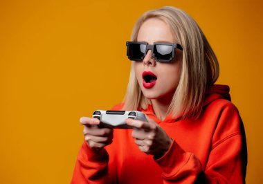 Güneş gözlüklü kız, joystick ile oynuyor.