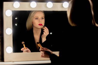 Güzel sarışın kadın makyaj aynasının yanında