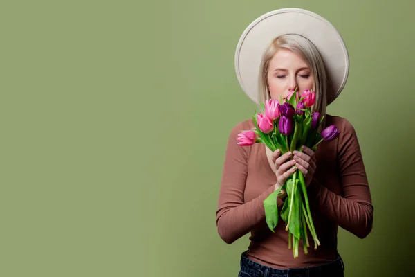 Beautiful woman in a hat with tulips bouquet — 스톡 사진