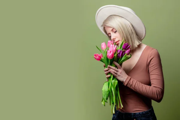 Piękna kobieta w kapeluszu z bukietem tulipanów — Zdjęcie stockowe