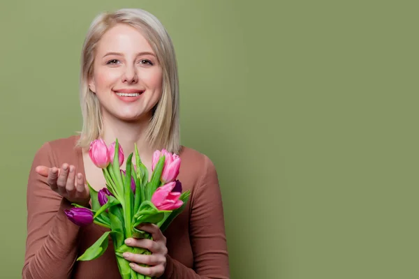 Piękna blondynka w brązowej bluzce z tulipanami — Zdjęcie stockowe