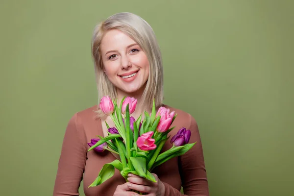 Krásná blondýnka v hnědé blůze s tulipány — Stock fotografie