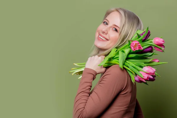 Belle fille blonde en chemisier brun avec des tulipes — Photo