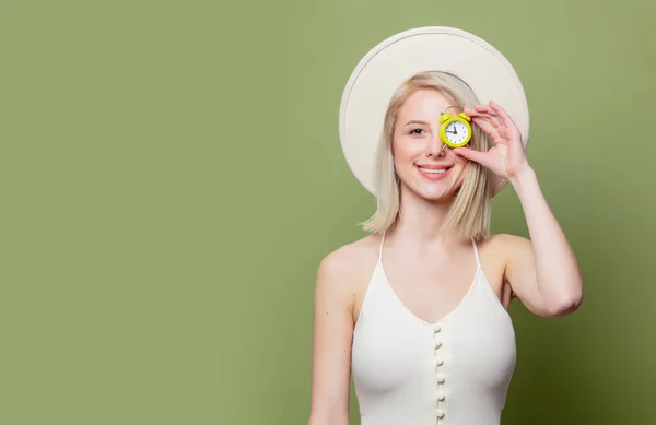 Beautiful blonde girl in a white hat and dress with little alarm clock — 스톡 사진