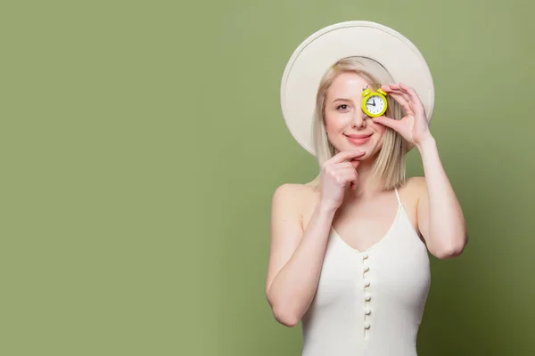 Beautiful blonde girl in a white hat and dress with little alarm clock — 스톡 사진