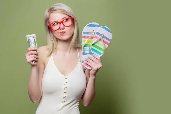 Mooi blond meisje in bril met geld en teenslippers — Stockfoto