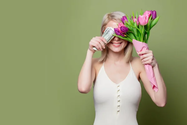 Sonriente chica rubia con tulipanes y efectivo —  Fotos de Stock