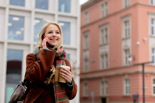 Woman with cup of coffee talking by mobile phone — Stock Photo, Image