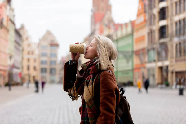 Красивая блондинка пьет кофе в старом городе — стоковое фото