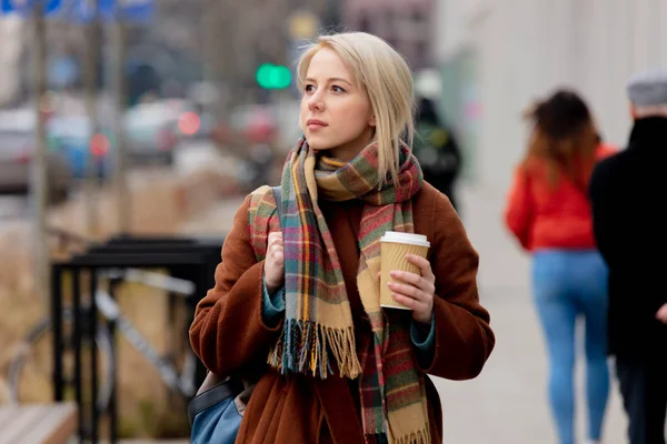 Hermosa mujer rubia con taza de café en la calle de la ciudad —  Fotos de Stock