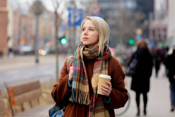 Mulher loira bonita com xícara de café na rua da cidade — Fotografia de Stock