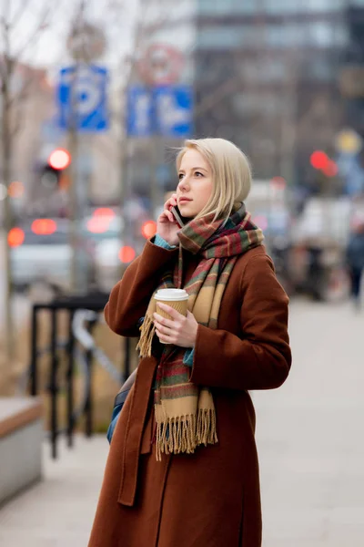 Woman with cup of coffee talking by mobile phone — 스톡 사진