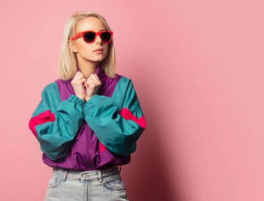 Beautiful blonde woman in sunglasses and 90s clothes