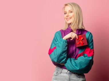 Beautiful blonde woman in 90s clothes with gift box 