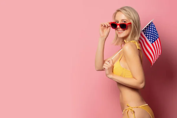 Woman in yellow bikini and sunglasses with USA flag — Stock Photo, Image