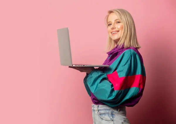 Mooie blonde vrouw in jaren 90 kleding met laptop computer — Stockfoto
