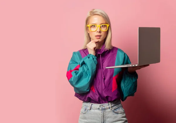 Mulher loira bonita em roupas dos anos 90 com computador portátil — Fotografia de Stock