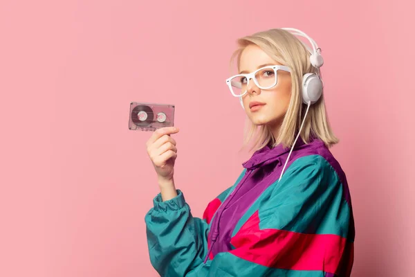 Kobieta w latach 90-tych ubrania ze słuchawkami i kasetą audio — Zdjęcie stockowe