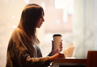 Not defterli esmer kadın bir kafede çalışıyor.