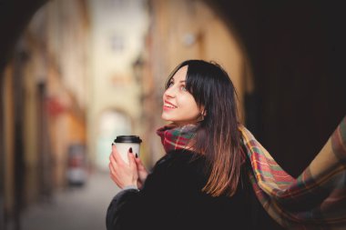 Esmer kadın eski kasabada bir fincan kahveyle 