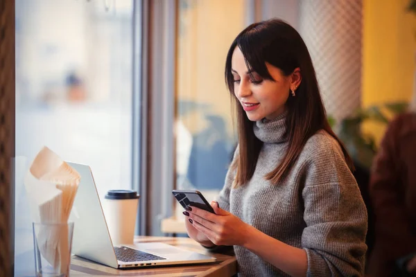 Donna con computer portatile e telefono cellulare — Foto Stock