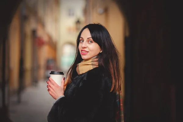 Bruneta žena s šálkem kávy ve starém městě — Stock fotografie