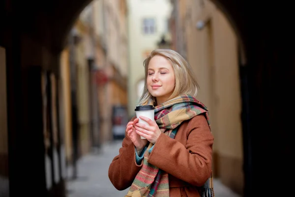 Blond kvinna med kopp kaffe i gamla stan — Stockfoto