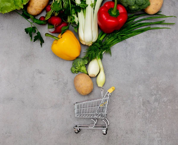 Супермаркет візок і овочі на столі — стокове фото