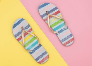 Yaz aylarında sandalet sarı ve pembe arka planda terlik giyer. Görünümün üstünde 