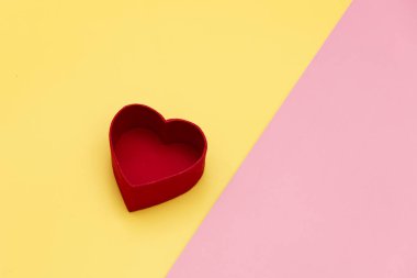 Sarı ve pembe arka planda kalp şeklinde hediye kutusu 