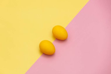 Sarı ve pembe arka planda iki renk Paskalya yumurtası..