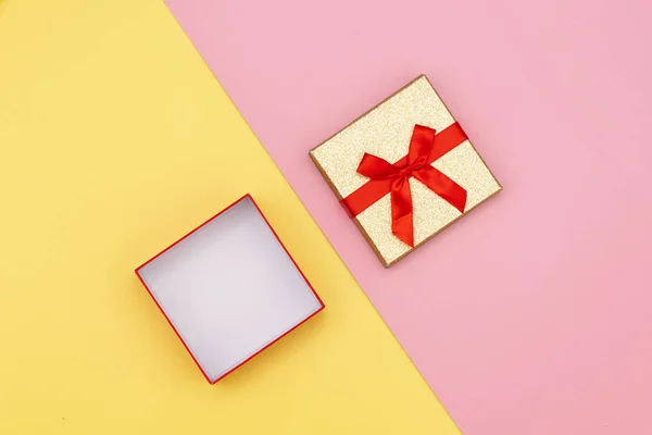 ピンクと黄色の背景に小さなオープンギフトボックス 上の図 — ストック写真