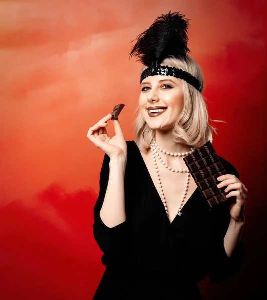Krásná Blondýna Žena Dvacátých Letech Oblečení Plátkem Čokolády Červeném Pozadí — Stock fotografie