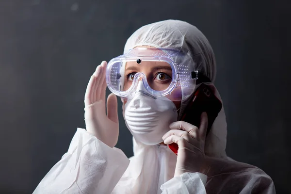 medic woman wearing protective clothing against the virus is usi