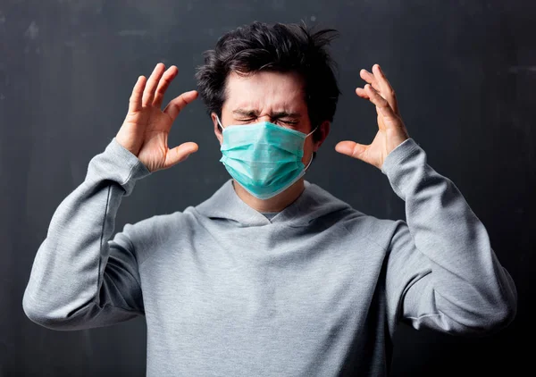 Ung, hvit mann med beskyttende maske med hodepine – stockfoto