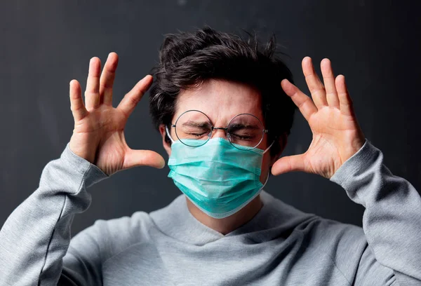 Joven hombre blanco en gafas y máscara protectora con dolor de cabeza —  Fotos de Stock