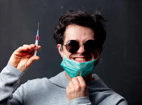 Joven hombre blanco en máscara protectora y gafas de sol con jeringa v —  Fotos de Stock