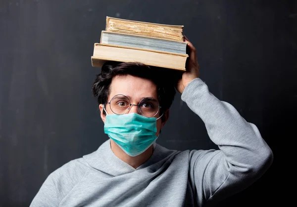 Jovem homem branco em óculos e máscara protetora com livros — Fotografia de Stock