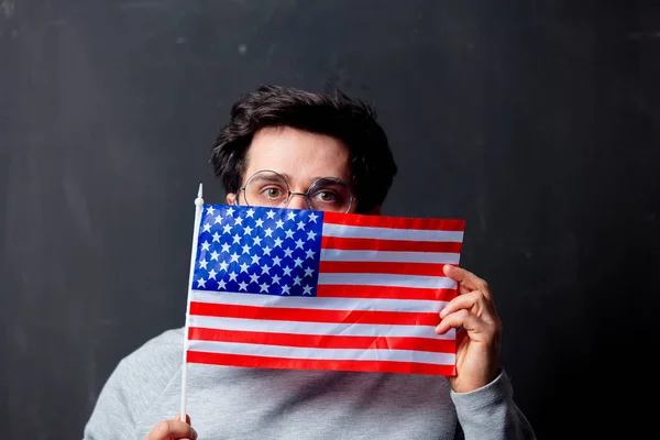 Man in glasses with USA flag on dark background — Stock Photo, Image