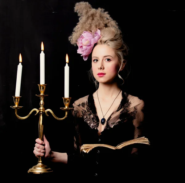 漂亮的金发女伯爵，有一本书和烛台 — 图库照片
