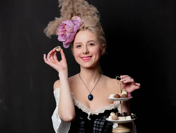 Mooie blonde gravin met chocolade snoepjes — Stockfoto