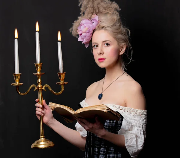 Hermosa condesa rubia con un libro y un candelero —  Fotos de Stock