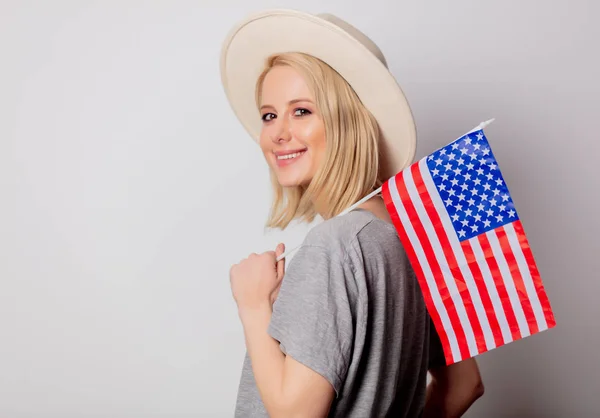 Mooie blonde vrouw in cowboy hoed met Usa vlag op witte rug — Stockfoto