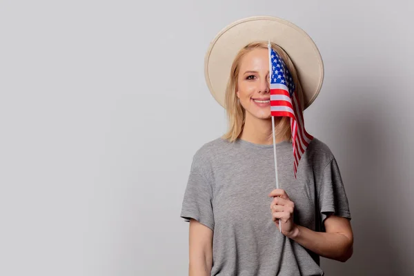 Mooie blonde vrouw in cowboy hoed met Usa vlag op witte rug — Stockfoto