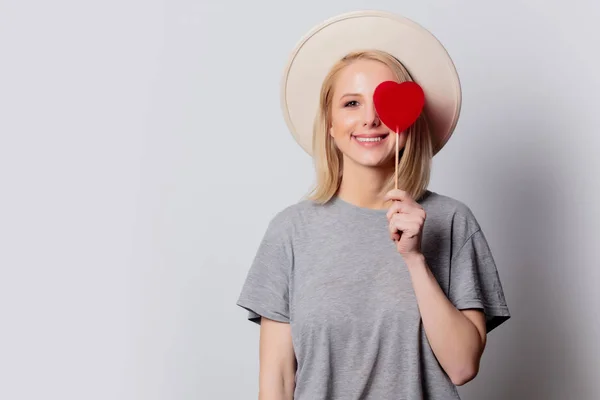 Bella donna bionda con caramelle a forma di cuore su backgroun bianco — Foto Stock