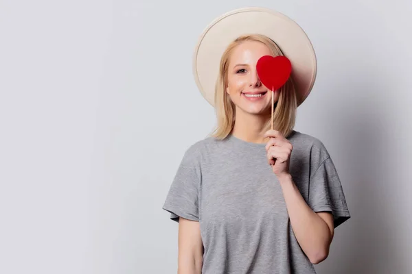 Hermosa mujer rubia con corazón en forma de caramelo sobre fondo blanco —  Fotos de Stock